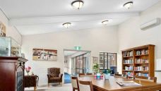 Bupa-Aged-Care-Campbelltown-Library-room-with-chairs-and-books